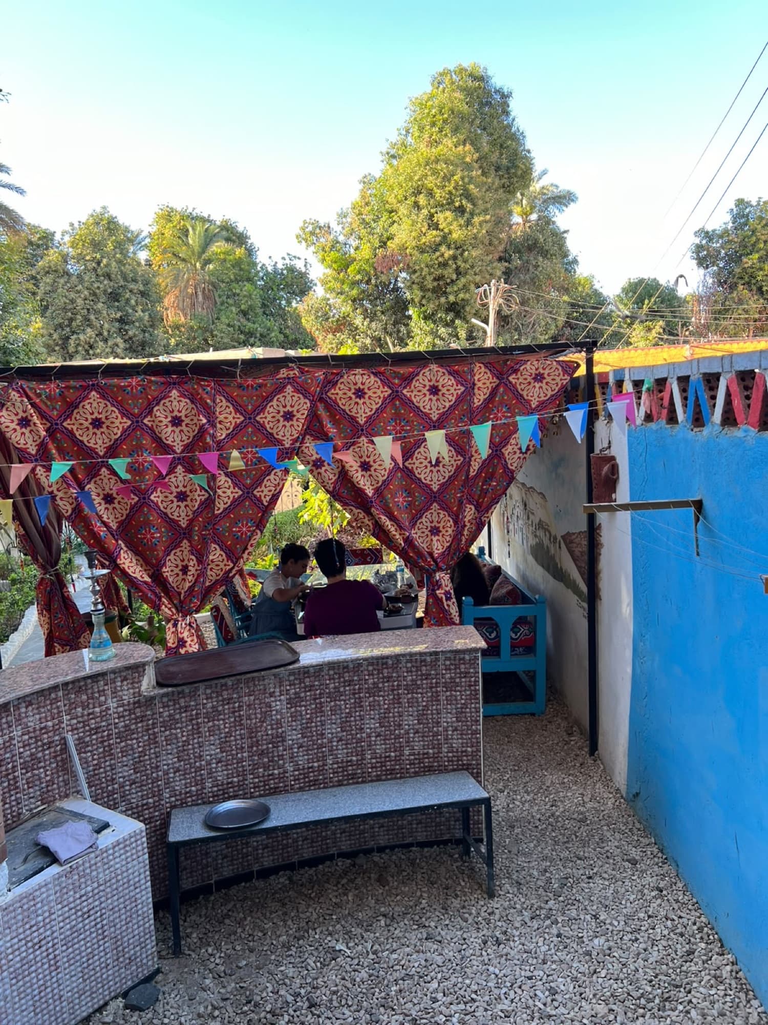 A shaded courtyard with patterned canopies and bunting