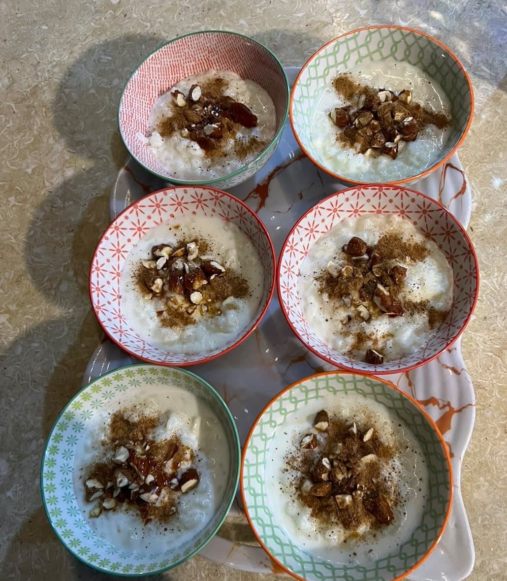 Bowls of creamy rice pudding topped with nuts and cinnamon