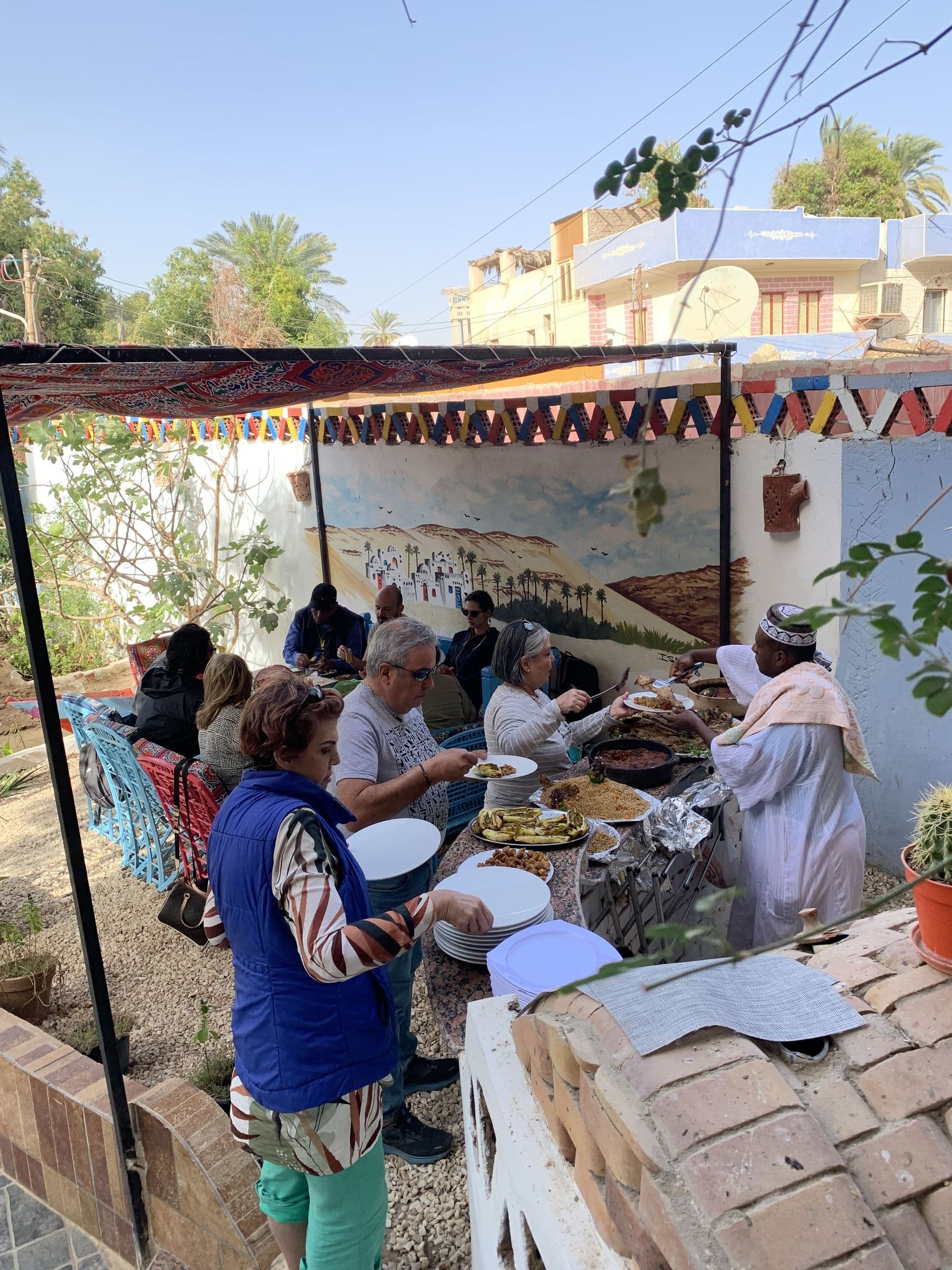 Guests sharing a traditional Nubian lunch in the courtyard at Mango Guesthouse