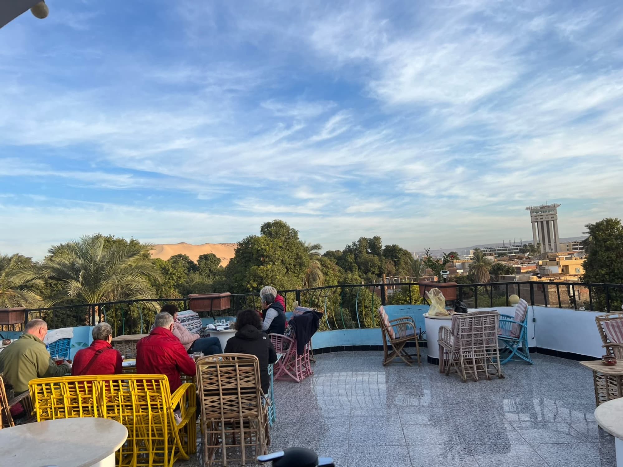 The rooftop terrace looking across palm trees and the Nile to the dunes of the west bank