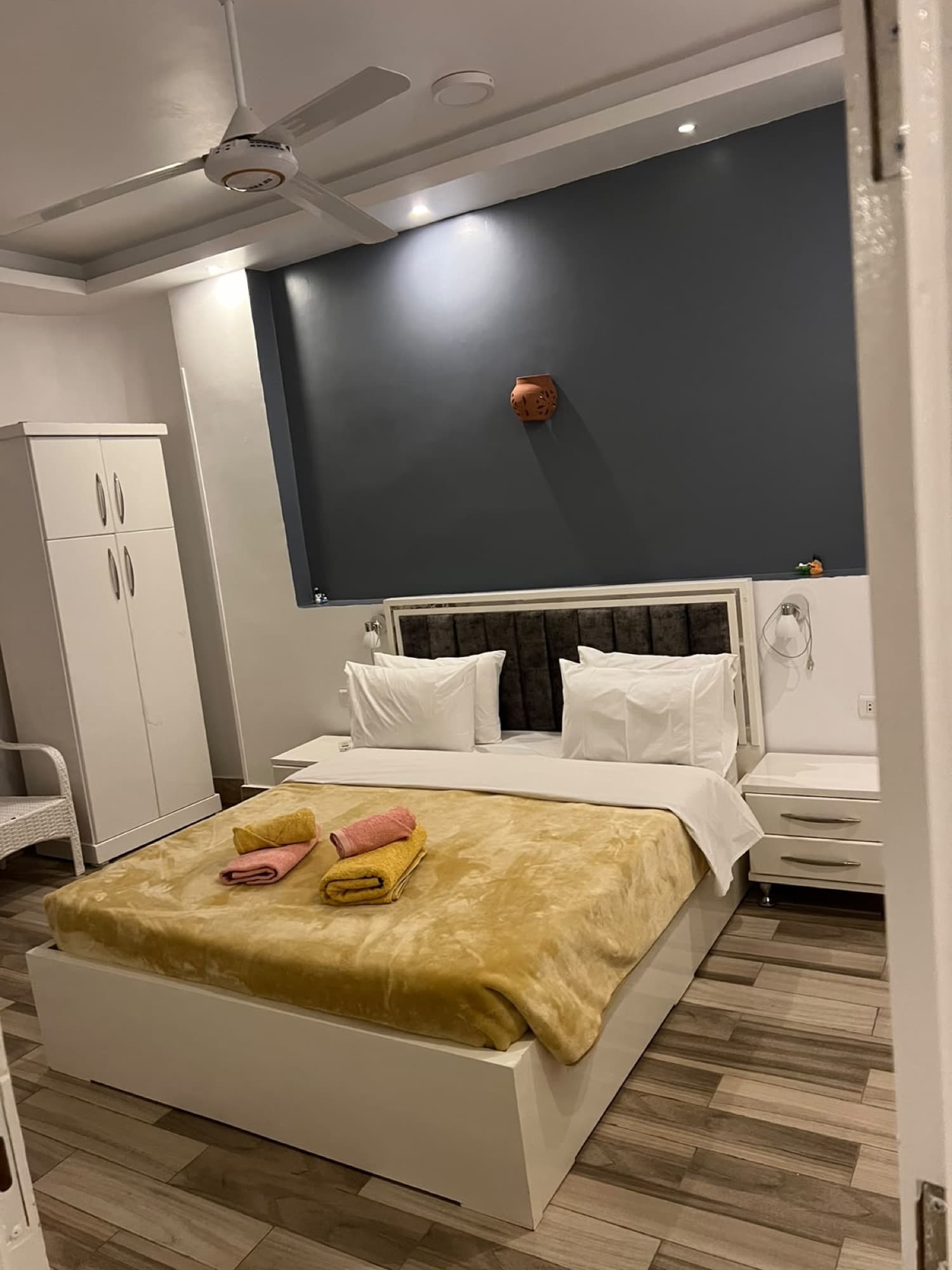 A modern double room with a golden bedspread and wood floors