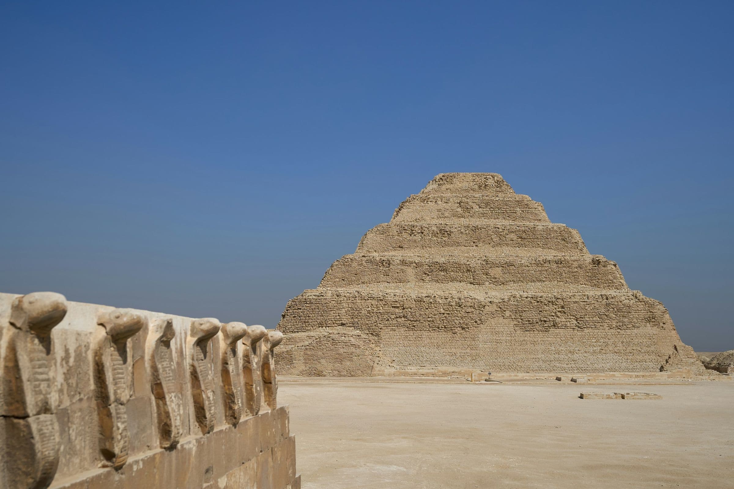 The Step Pyramid of Djoser beyond the cobra frieze at Saqqara