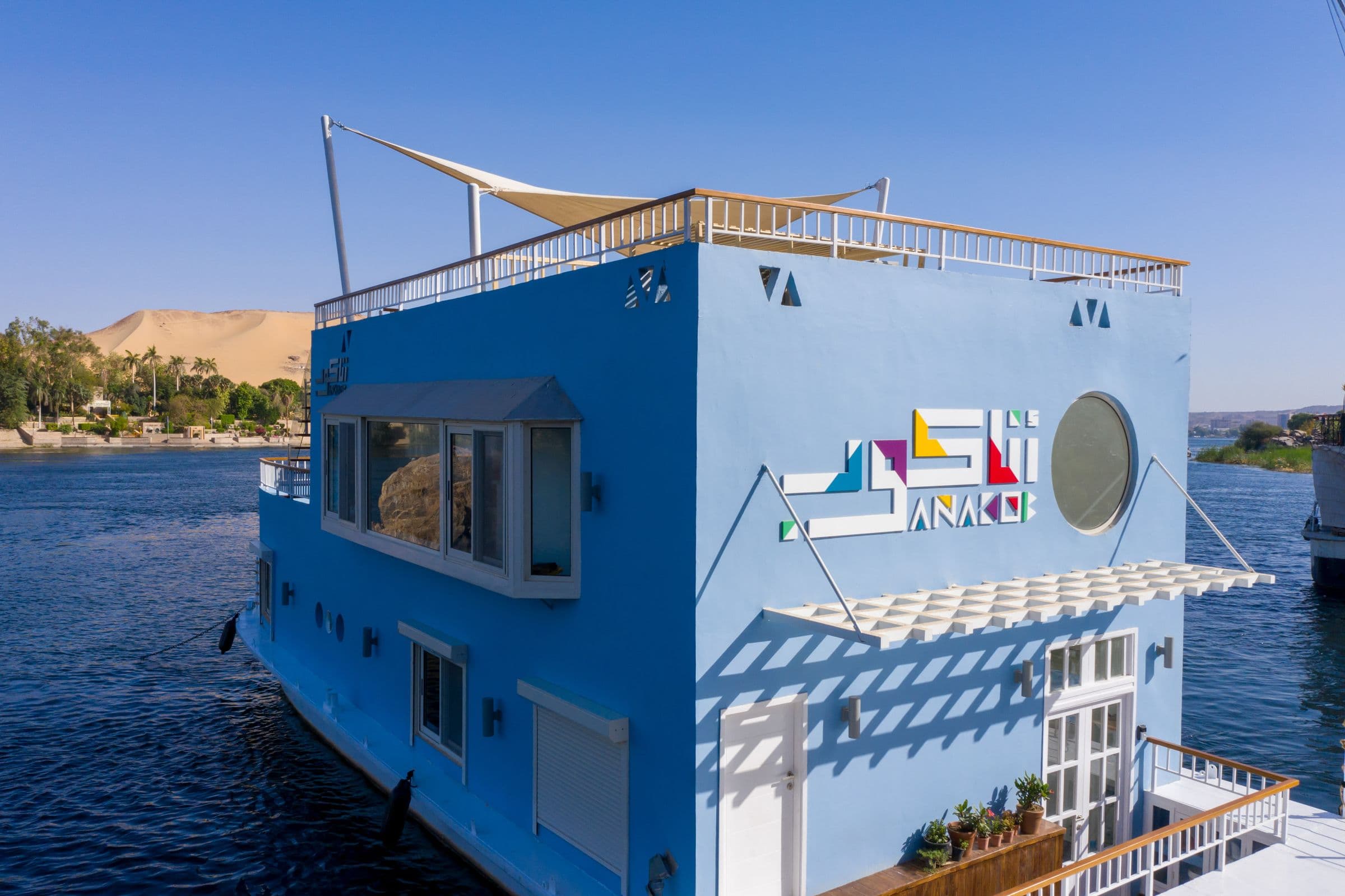 The blue Anakob houseboat with its rooftop sundeck