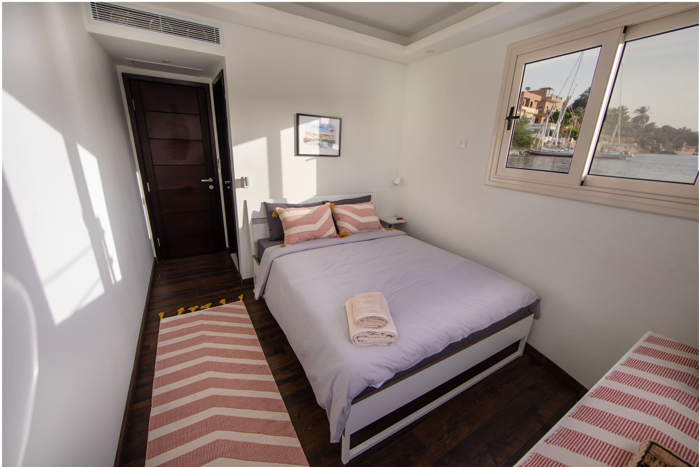 A bright bedroom with striped kilim rugs aboard Anakob